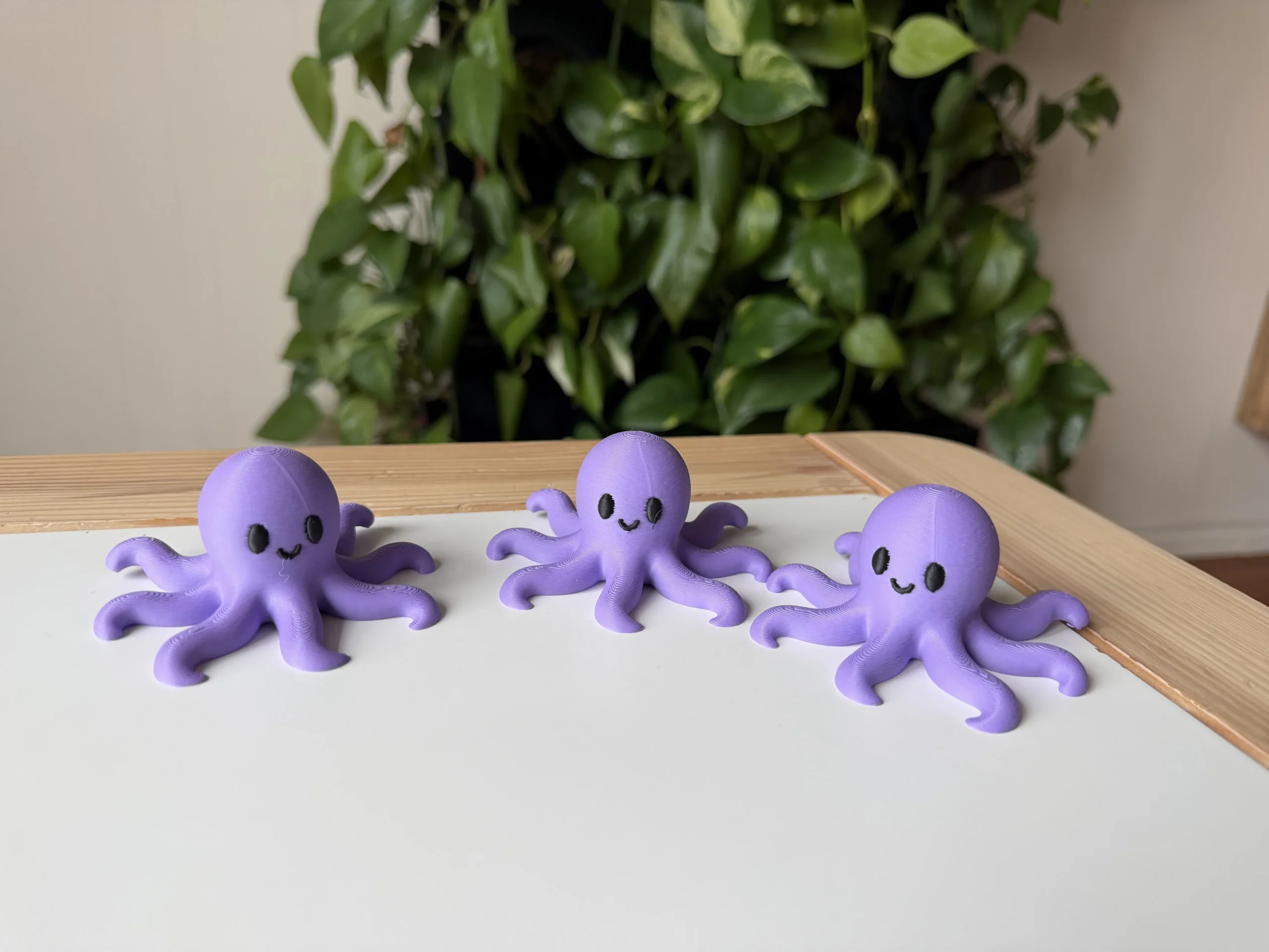 Figuras decorativas de pulpo kawaii impresas en 3D en color morado con ojos negros y expresión sonriente